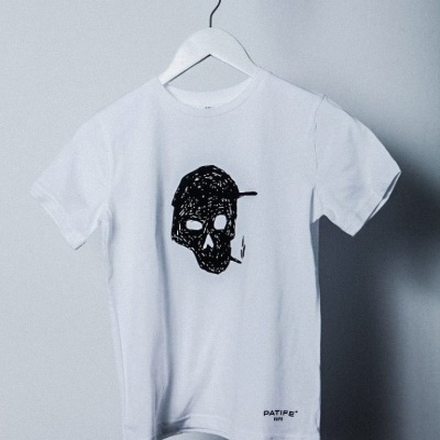T-shirt branca com crânio preto desenhado e texto PATIFE® TM