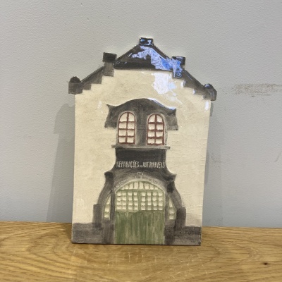 Miniatura de casa decorativa em cerâmica com porta verde e janelas vermelhas