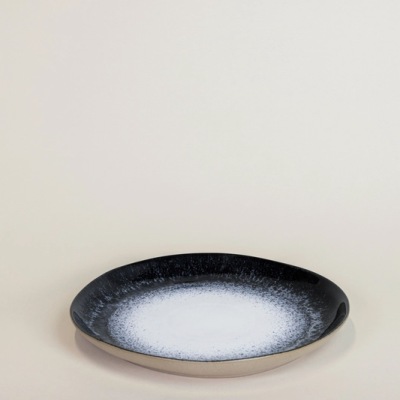 Prato redondo em cerâmica com padrão degradê branco para preto.