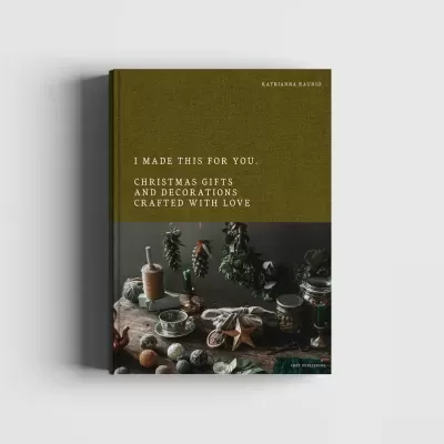 Livro sobre presentes e decorações de Natal com capa verde e fotografia de objetos decorativos