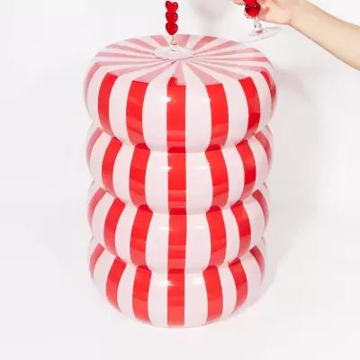 Mesa decorativa com padrão riscas vermelhas e brancas e duas taças de vidro com corações vermelhos