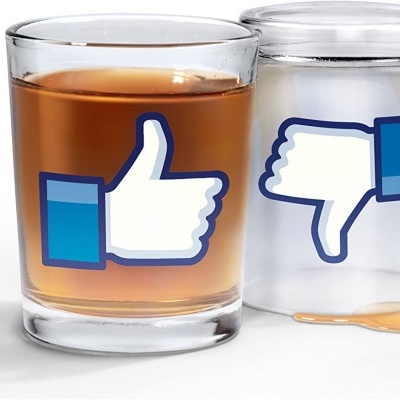 Dois copos de vidro um com líquido e símbolo de polegar para cima e outro de cabeça para baixo com polegar para baixo