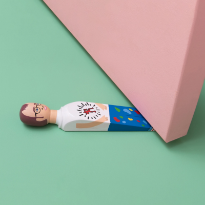 Figura humana pintada em madeira azul, branco e cores, sob porta rosa em fundo verde.