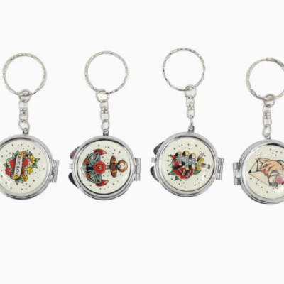 Quatro porta-chaves de metal redondos com diferentes imagens de tatuagens clássicas coloridas no centro