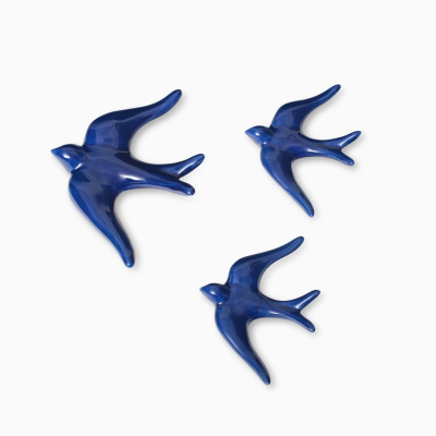 Três pássaros decorativos em azul brilhante sobre fundo branco