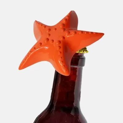 Abridor de garrafas estrela do mar laranja sobre tampa de garrafa de vidro castanho