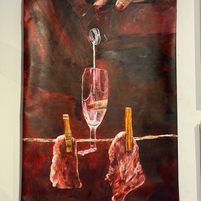 Pintura com mão a verter líquido em copo de champanhe com pedaços de carne pendurados