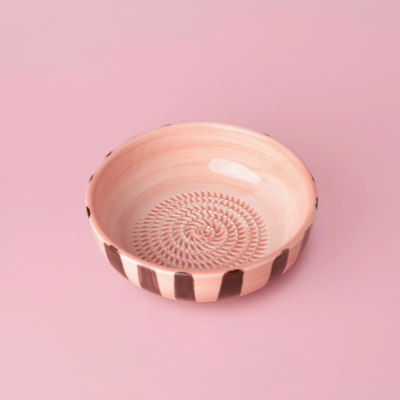 Taça de cerâmica rosa com padrões pretos sobre fundo rosa