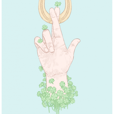 Mão com trevos segurando ferradura dourada em fundo azul claro