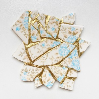 Peças de cerâmica partidas com padrão floral azul e castanho