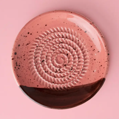 Prato cerâmico rosa com textura e manchas castanhas