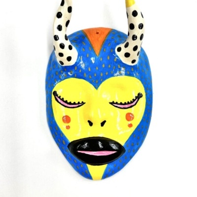 Máscara decorativa colorida em cerâmica com chifres e feições estilizadas