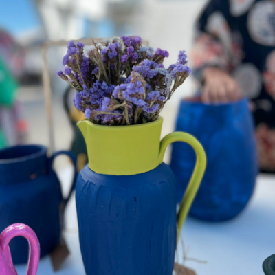 Jarro azul com bocal verde e flores secas roxas