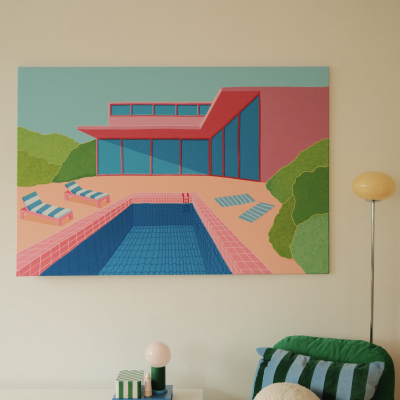 Quarto com pintura de piscina colorida, lâmpada de pé e cadeira verde com almofadas