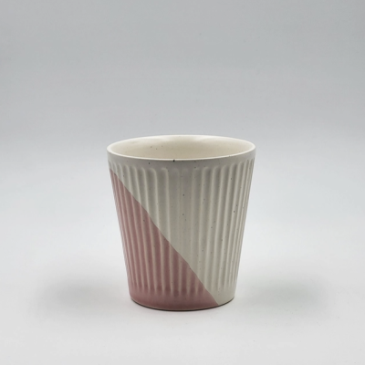Copo de cerâmica branco e rosa com padrão estriado