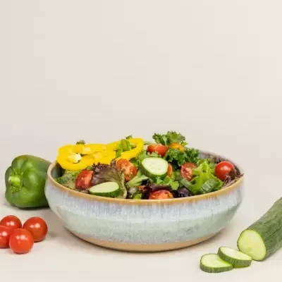 Salada variada em taça cerâmica com legumes frescos ao lado