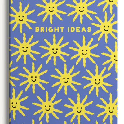 Caderno azul com sóis amarelos sorridentes e texto 'BRIGHT IDEAS'.