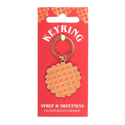 Porta-chaves com pendente em forma de waffle na embalagem vermelha com texto branco.