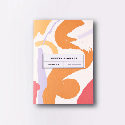 Planner semanal com capa abstrata em laranja, vermelho e lilás com etiqueta central