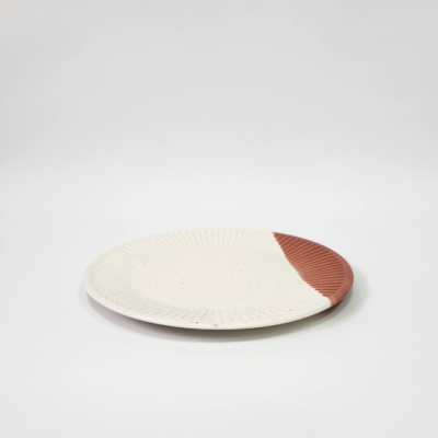 Prato redondo de cerâmica branco e castanho-avermelhado com textura canelada