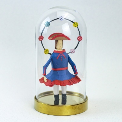 Figura decorativa de criança em papel debaixo de campânula de vidro