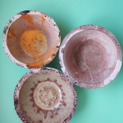 Três copos de vidro rosa com padrões em fundo azul