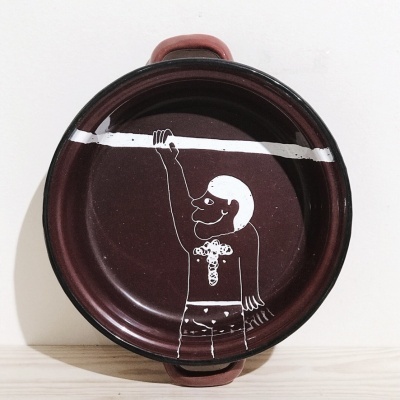 Panela de metal vinho com desenho branco de figura humana segurando barra