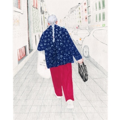 Pessoa de costas a caminhar numa rua com casaco azul estampado, calças vermelhas e sacolas nas mãos.