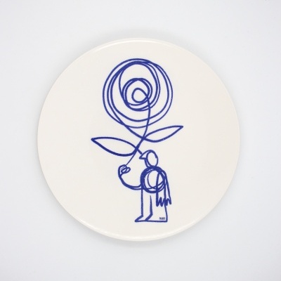 Prato branco redondo com desenho azul de uma pessoa segurando uma flor abstrata.