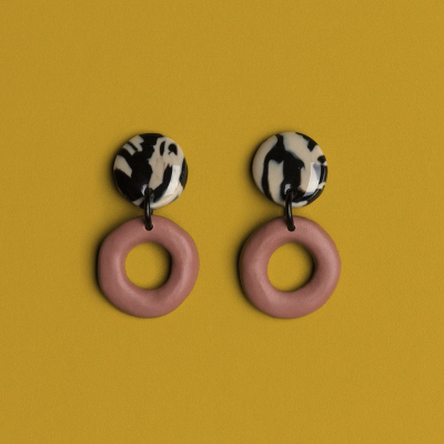 Brincos redondos com padrão preto e branco e anéis rosa