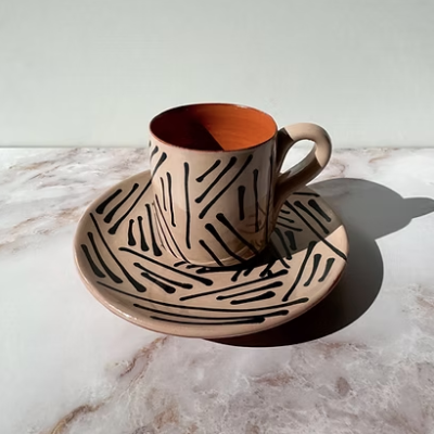 chávena e pires de cerâmica com padrão geométrico preto