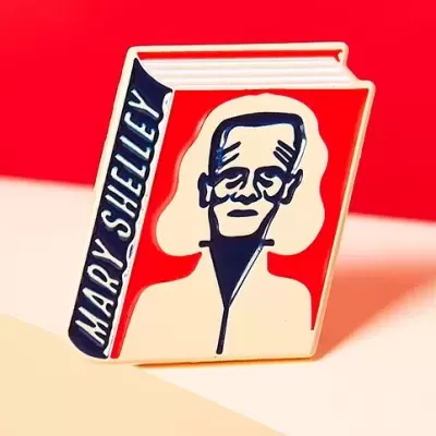 Broche de livro com capa vermelha e ilustração em preto e branco