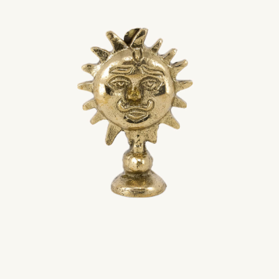 Estatueta dourada de sol com rosto humano e base redonda