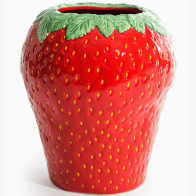 Vaso cerâmico vermelho em forma de morango com folhas verdes no topo