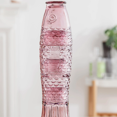 Copos de vidro cor-de-rosa empilhados em forma de peixe com textura de escamas