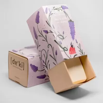 Sabonetes em embalagem decorada com flores lilases e verdes, um aberto e outro fechado.