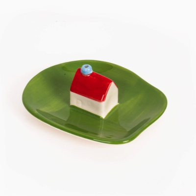 Prato verde com casa decorativa em cerâmica no centro