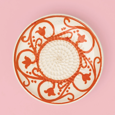 Prato redondo decorado com padrão floral laranja e textura em espiral no centro