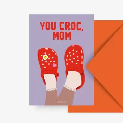 Cartão lilás com sapatos Crocs vermelhos e texto 'YOU CROC, MOM'