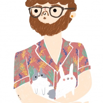 Homem com barba e óculos segurando dois coelhos em camisa floral colorida