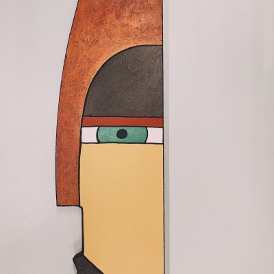 Escultura abstrata de rosto estilizado em várias cores e texturas