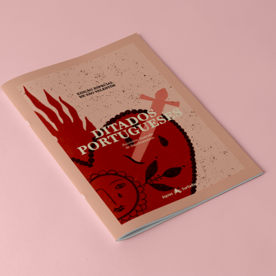 Livro brochura Ditados Portugueses com capa ilustrada em tons de rosa e vermelho.