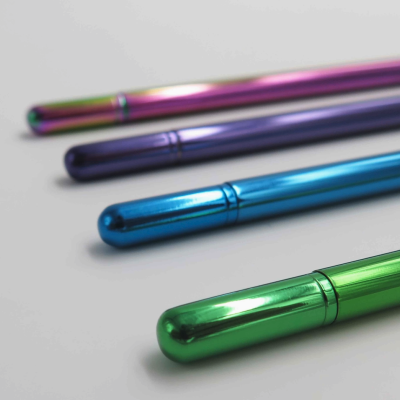 Quatro canetas metálicas coloridas alinhadas sobre fundo branco