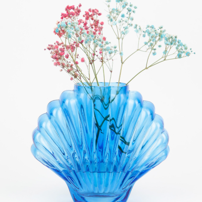 Vaso azul em forma de concha com flores cor-de-rosa e azul claro