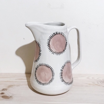 Jarro branco de cerâmica com padrões circulares rosa e pretos
