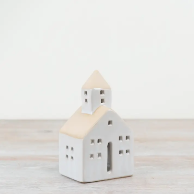 Casa decorativa cerâmica branca com telhado bege e janelas em superfície de madeira