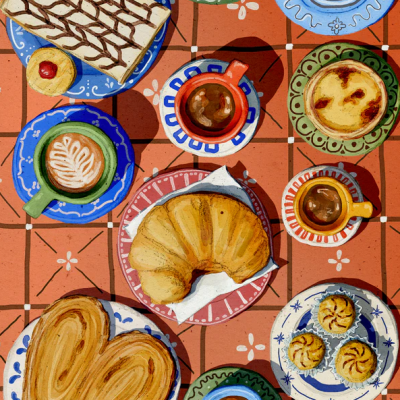 mesa com diversos pratos e chávenas de café e pastelaria