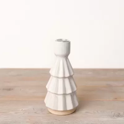 Castiçal cerâmico branco com base bege em mesa de madeira