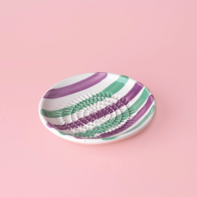 Prato de cerâmica branco com riscas verdes e roxas e textura circular