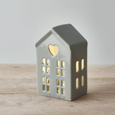 Casa decorativa cinzenta com luz interior e janelas recortadas